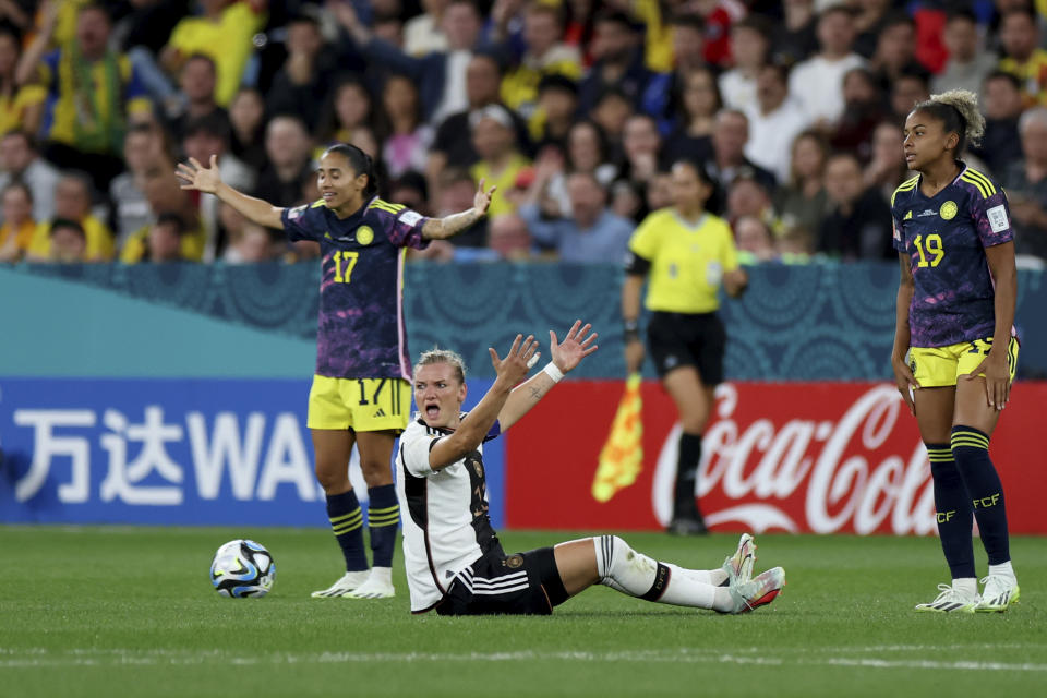 Germany's Alexandra Popp, on the ground, looks for a penalty call, between Colombia's Carolina Arias, left, and Jorelyn Carabali during the Women's World Cup Group H soccer match between Germany and Colombia at Sydney Football Stadium in Sydney, Australia, Friday, July 28, 2023. (AP Photo/Sophie Ralph)