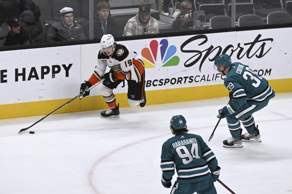 Anaheim Ducks right wing Troy Terry (19) keeps the puck away from San Jose Sharks center Logan Couture (39) and left wing Alexander Barabanov (94) during the second period of an NHL hockey game Saturday, Jan. 20, 2024, in San Jose, Calif. (AP Photo/Nic Coury)