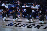 Members of the New Orleans Pelicans kneel for the National Anthem prior to the first half of an NBA basketball game against the Memphis Grizzlies Monday, Aug. 3, 2020 in Lake Buena Vista, Fla. (AP Photo/Ashley Landis, Pool)