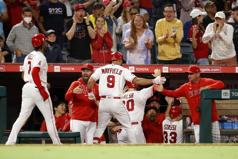 Los Angeles Angels' Jack Mayfield (9), center, is congratulated in the dugout after hitting a home run during the fourth inning of a baseball game against the New York Yankees in Anaheim, Calif., Monday, Aug. 30, 2021. (AP Photo/Ringo H.W. Chiu)