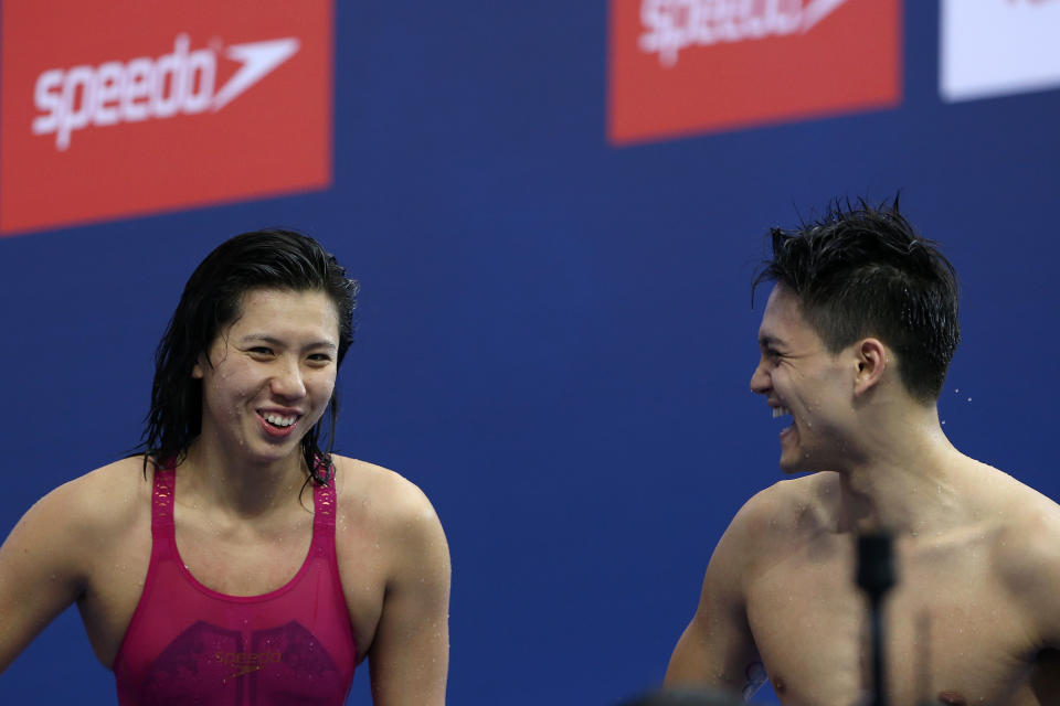 Amanda Lim (left) and Joseph Schooling smile and chat during the 4x50m medley relay at the 2018 FINA Swimming World Cup in Singapore.