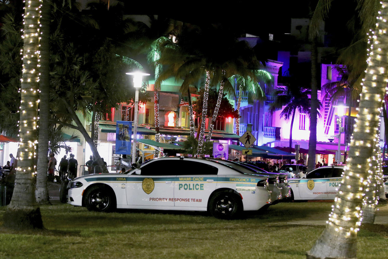 Miami-Dade Police Department personnel are seen on Ocean Drive Saturday night before the midnight curfew imposed by the City of Miami Beach, Fla., Saturday March 26, 2022. Miami Beach officials have spent recent years trying to control the raucous crowds, public drinking and growing violence associated with the city's world-famous South Beach neighborhood during spring break. (Pedro Portal/Miami Herald via AP)