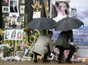 <p>Britain’s Prince William, left, and Prince Harry place flowers and tributes taken from members of the public at the Golden Gates of Kensington Palace, London, Aug. 30, 2017 on the eve of the 20th anniversary of their mother’s death. (Photo: Alastair Grant/AP) </p>