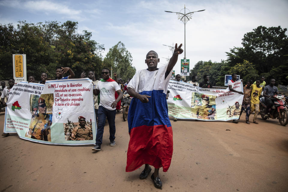 Young men chant slogans against the power of Lieutenant-Colonel Damiba, against France and pro-Russia, in Ouagadougou, Burkina Faso, Friday Sept. 30, 2022. Residents say gunfire rang out early in the morning and the state broadcaster has gone off the air, fueling fears that another coup is underway. The developments Friday come just after coup leader-turned-president, Lt. Col. Paul Henri Sandaogo Damiba, returned from a trip to the U.N. General Assembly. (AP Photo/Sophie Garcia)