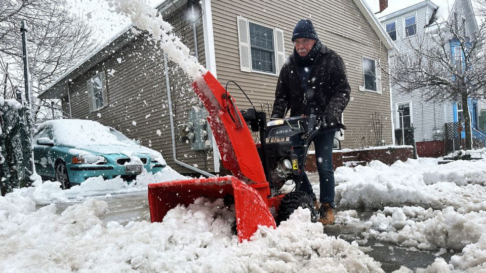 Phil Cloutier removes heavy, wet snow after an early-spring Nor'easter, Thursday, April 4, 2024, in Portland, Maine. - David Sharp/AP