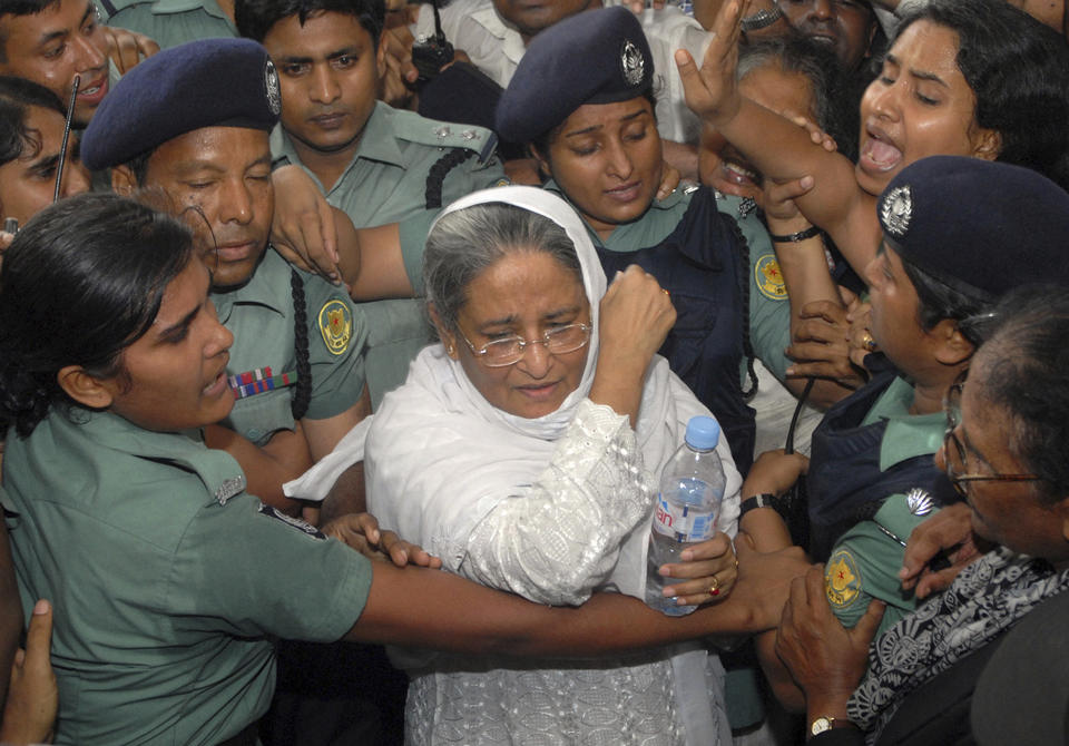 FILE- Police escort former Bangladeshi Prime Minister and Awami League President Sheikh Hasina, center, to a court after she was arrested on extortion charges in Dhaka, Bangladesh, July 16, 2007. The elections in Bangladesh are all about one person: Prime Minister Sheikh Hasina. Analysts predict that since the main opposition party is staying out of the Jan. 7 vote, the 76-year-old leader is practically guaranteed her fifth term in office. (AP Photo/Abu Taher Khokon, File)