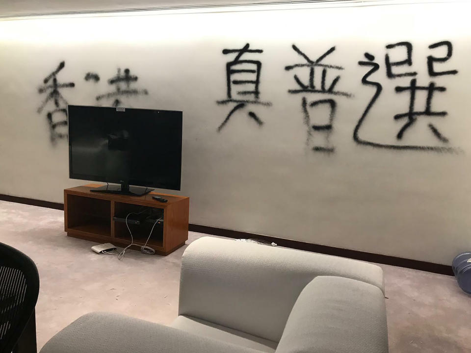 In this July 3, 2019, file photo, damage to the lobby of the Legislative Council following a break-in by protesters is seen during a media tour, Wednesday, July 3, 2019, in Hong Kong. Characters read "Hong Kong needs real elections." (AP Photo/Johnson Lai)