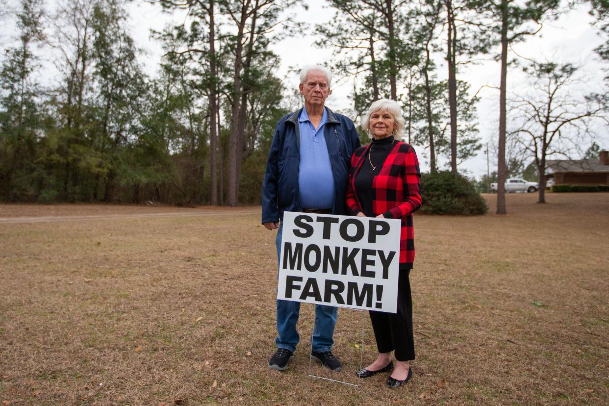 Johnny and Penny Reynolds stand in their front yard with a sign that reads "STOP MONKEY FARM!" The monkey breeding facility is slated to be built adjacent to their property in Bainbridge, Georgia.