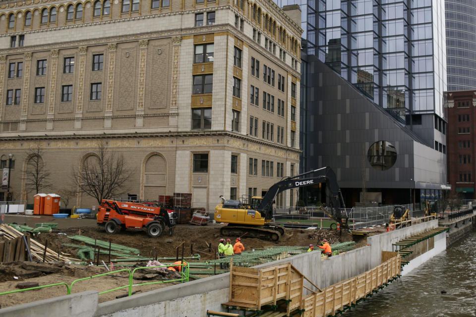 Construction workers are seen working along the river downtown on Jan. 31, 2024, in Grands Rapids, Mich. Michigan will be a key state in determining the outcome of the upcoming 2024 presidential election, with the economy on the minds of many voters in the state. (AP Photo/Kristen Norman)