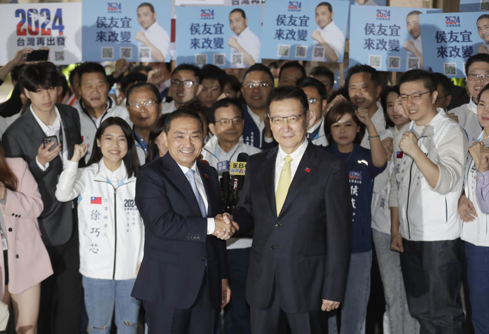 Taiwan's Nationalist Party presidential candidate Hou Yu-ih, center left, and his vice president candidate Chao Shao-kang pose for medias outside of Central Election Commission in Taipei, Taiwan, Friday, Nov. 24, 2023. (AP Photo/ Chiang Ying-ying)