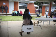 An Indigenous Tzotzil woman walks to set up a voting booth during a non-binding national referendum on whether Mexican ex-presidents should be tried for any illegal acts during their time in office, at the Corazon de Maria community, in Chiapas state, Mexico, Sunday, August 1, 2021. (AP Photo/Emilio Espejel)