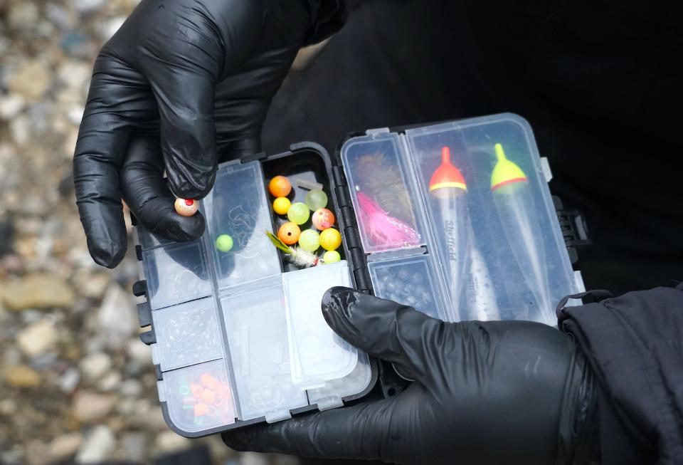 Pat Kiehm of Milwaukee looks through a tackle box to select a bead during a steelhead fishing outing on the Menomonee River in Wauwatosa. The bead simulates a fish egg and is an effective lure, especially for trout.