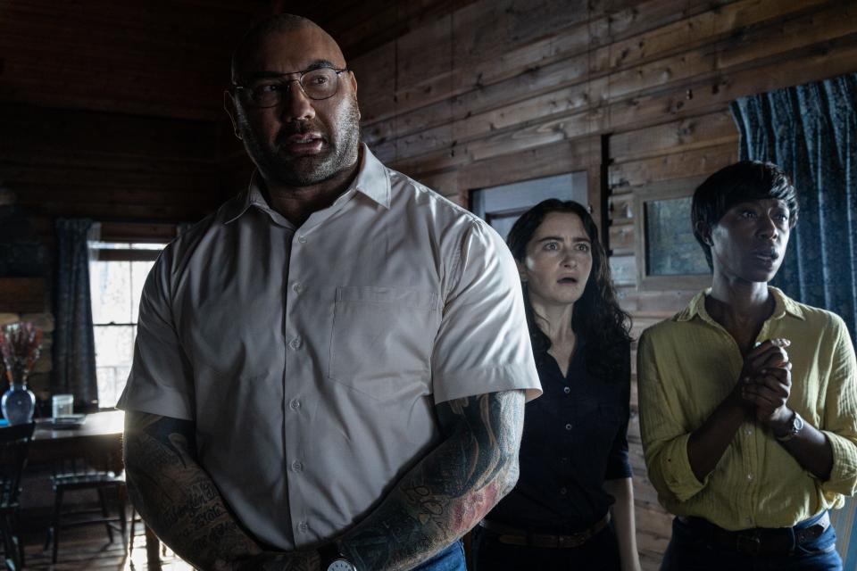 Leonard (Dave Bautista, far left), Adriane (Abby Quinn) and Sabrina (Nikki Amuka-Bird) disrupt a family's vacation with a dreadful choice  in M. Night Shyamalan's thriller "Knock at the Cabin."