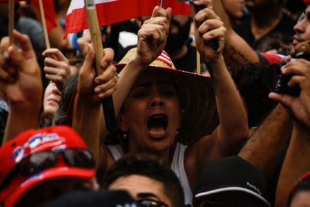 Demonstrators react while celebrating the official resignation of now ex-governor of Puerto Rico Ricardo Rossello, in San Juan, Puerto Rico