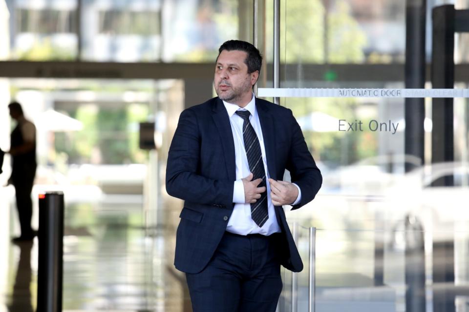 A man in front of glass doors.