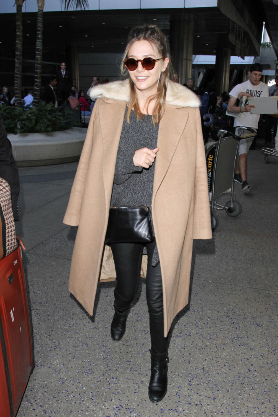 Elizabeth Olsen spotted at LAX in Los Angeles wearing a chic camel coat and black ankle booties. (Photo: Getty)