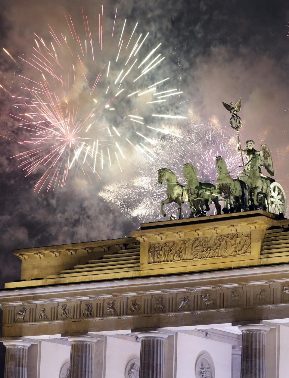 Fireworks light the sky above the Quadriga at the Brandenburg Gate shortly after midnight in Berlin, Germany, Sunday, Jan. 1, 2017. Hundred thousands of people celebrated New Year's Eve welcoming the new year 2017 in Germany's capital. (AP Photo/Michael Sohn)