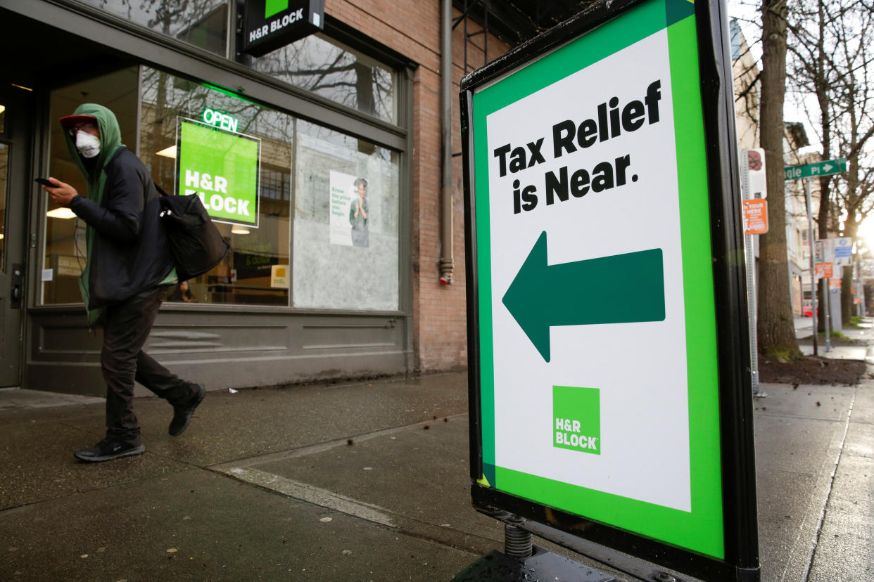 A pedestrian wearing a facemark walks past an H&R Block tax preparation office as efforts continue to help slow the spread of coronavirus disease (COVID-19) in Seattle, Washington, U.S. REUTERS/Jason Redmond