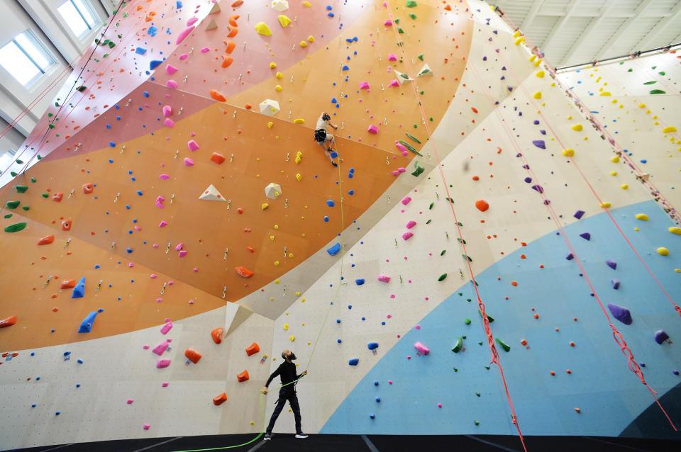 At Ascend Erie climbing gym, employees Chelsea Huddleston, 26, top, and Wade Desai, 35, check routes on the 52-foot wall.