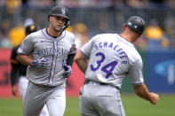 Colorado Rockies' Sean Bouchard (12) rounds third to greetings from third base coach/infield coach Warren Schaeffer (34) after hitting a solo home run off Pittsburgh Pirates starting pitcher Bailey Falter during the second inning of a baseball game in Pittsburgh, Sunday, May 5, 2024. (AP Photo/Gene J. Puskar)