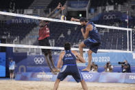 Daniele Lupo, right, of Italy, takes a shot as teammate Paolo Nicolai, center watches and Ahmed Tijan, of Qatar, defends during a men's beach volleyball quarterfinal match at the 2020 Summer Olympics, Wednesday, Aug. 4, 2021, in Tokyo, Japan. (AP Photo/Petros Giannakouris)