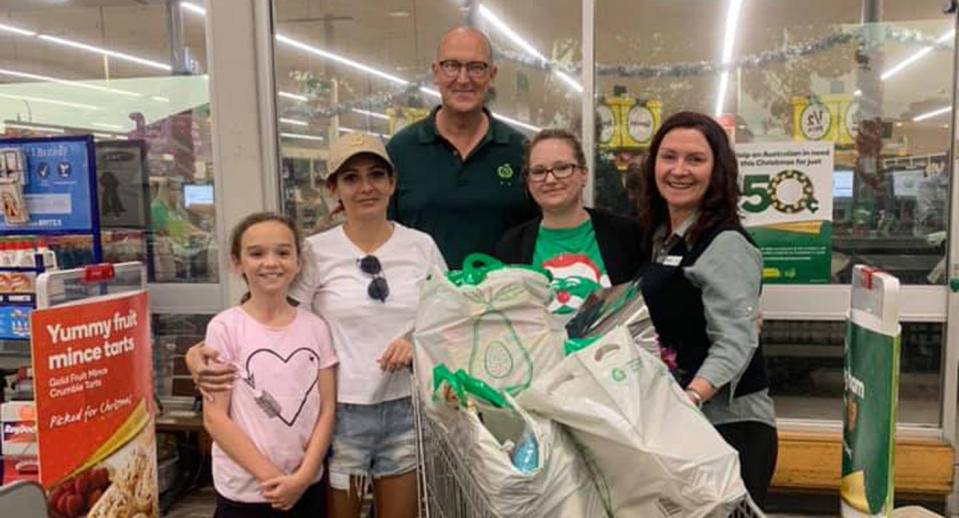 Anna Lawrence pictured in Woolworths with a trolley full of groceries. Also pictured is her daughter Kaela, 10, and two Woolworths staff members.