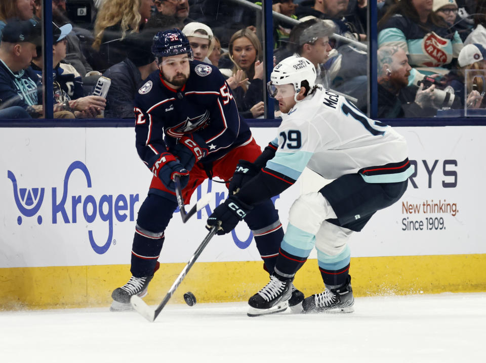 Columbus Blue Jackets forward Emil Bemstrom, left, passes the puck in front of Seattle Kraken forward Jared McCann during the first period NHL hockey game in Columbus, Ohio, Saturday, Jan. 13, 2024. (AP Photo/Paul Vernon)