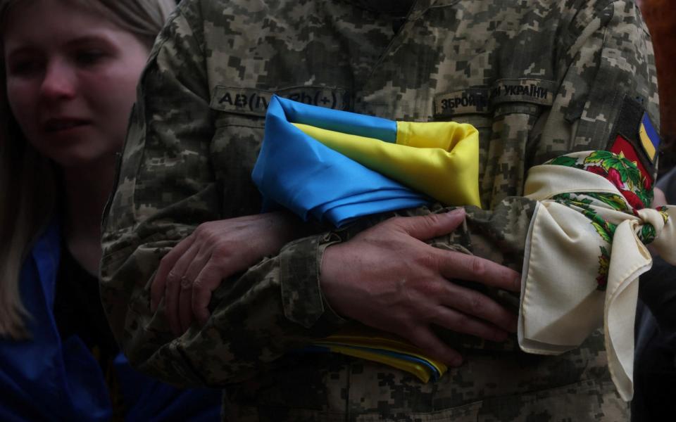 Taras Ratushnyi, the father of soldier Roman Ratushnyi, a well-known activist, holds his Ukrainian flag as he and friends, family, fellow soldiers and others attend Roman's burial service in Kyiv, Ukraine, as Russia's attack on Ukraine continues June 18, 2022. - REUTERS/Leah Millis