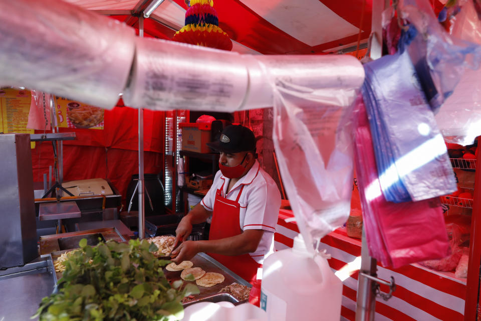 Bolsas de plástico biodegradables, de conformidad con la prohibición de las bolsas de plástico de 2020, cuelgan en un puesto de tacos en el centro de la Ciudad de México, el viernes 1 de enero de 2021. La actividad económica de Latinoamérica podría crecer un 3,7% en 2021 a medida que los países flexibilicen las restricciones implementadas para controlar la pandemia de coronavirus, pero el repunte será muy débil y en un escenario negativo podría ser incluso menor al 2%, según un informe del Banco Mundial. (AP Foto/Rebecca Blackwell)