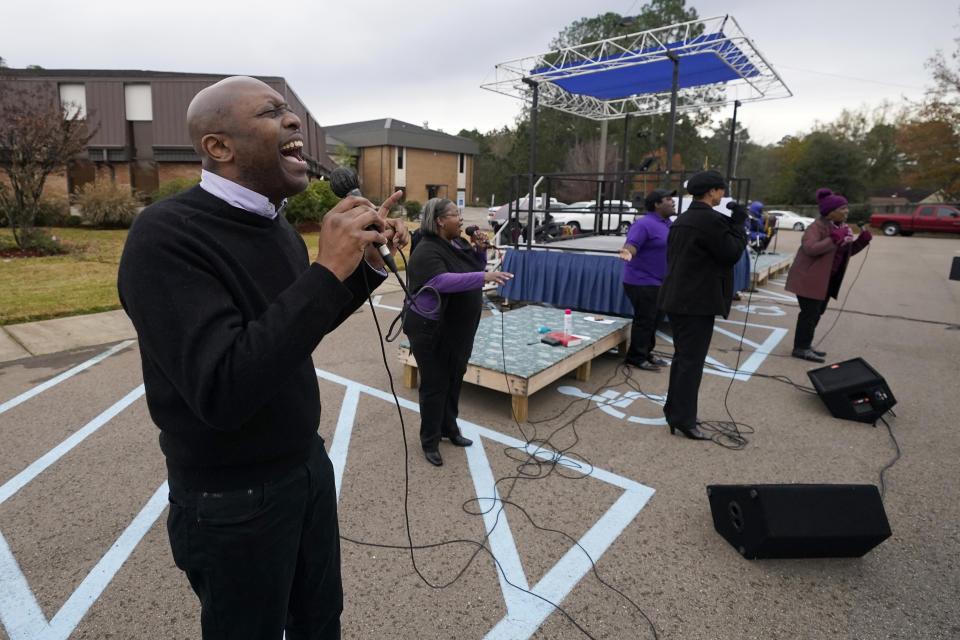 Choir member Ron Garry joins others in an opening song during First Sunday service at Anderson United Methodist Church, Dec. 6, 2020, in Jackson, Miss. The church has taken to using digital means by which to broadcast the majority of its services. However, following covid protocol, the congregants gather in the church's parking lot the first Sunday of each month to celebrate the receiving of communion in their private vehicles. (AP Photo/Rogelio V. Solis)