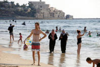 Muslim women wearing Hijabs (C) walk along the shore of the Mediterranean Sea at the beach in Tel Aviv, Israel August 22, 2016. REUTERS/Baz Ratner