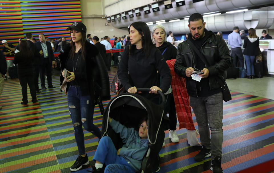 U.S. embassy employees and their families prepare to depart Simon Bolivar international airport in La Guaira, Venezuela, Friday, Jan. 25, 2019. Venezuelan President Nicolas Maduro on Wednesday gave the U.S. diplomats 72 hours to leave the country and close their hilltop embassy as he announced he was breaking diplomatic relations over the Trump administration's decision to recognize lawmaker Juan Guaido as interim president. (AP Photo/Rodrigo Abd)