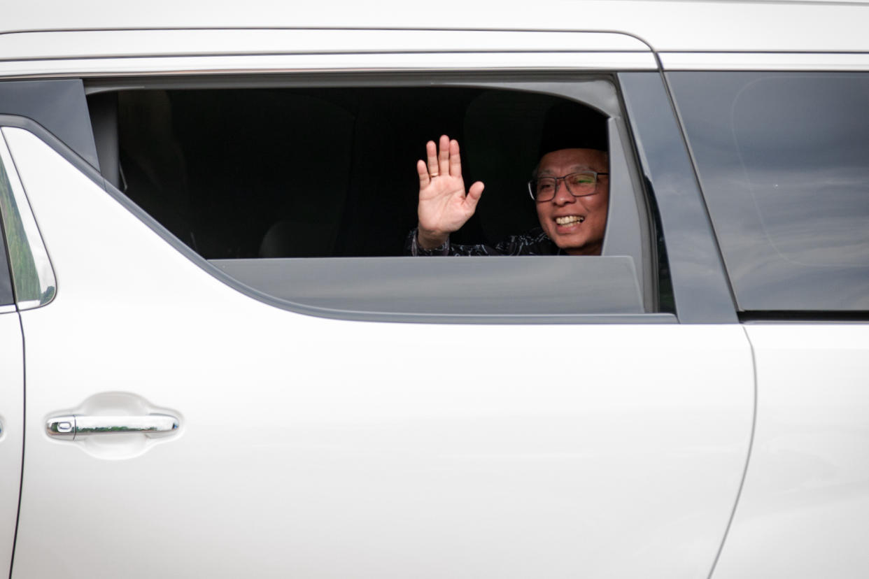 Prime Minister of Malaysia, Ismail Sabri, in a white car, waving at his supporters.