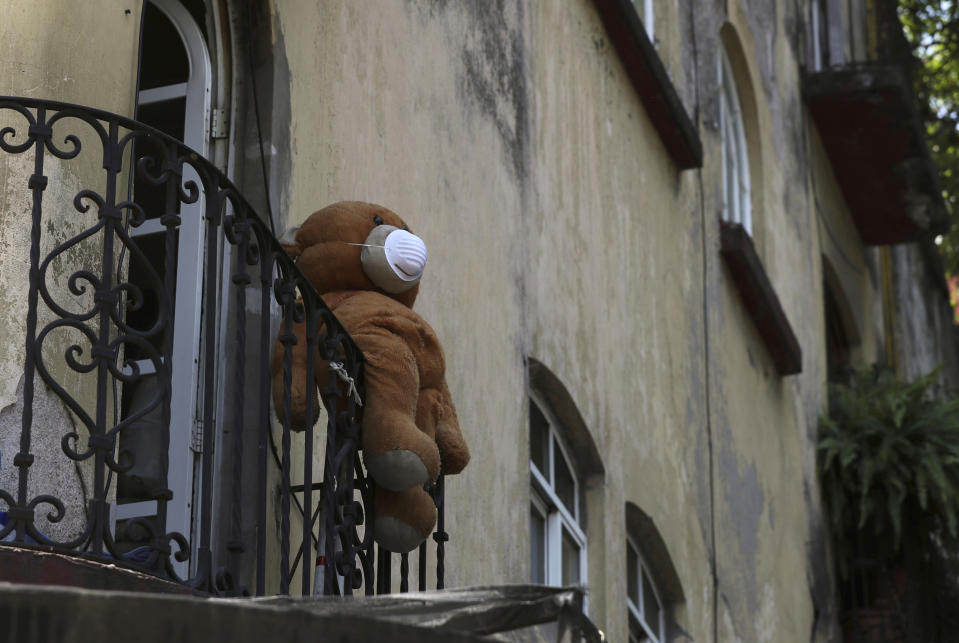 A teddy bear wearing a face mask hangs from a balcony in Mexico City, Thursday, April 9, 2020, as many stay indoors amid the spread of the new coronavirus. (AP Photo/Fernando Llano)