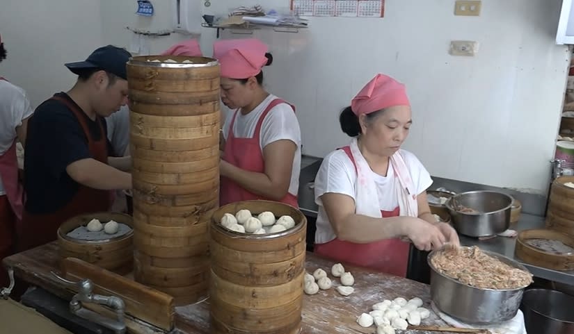 公正包子店員一如往常忙著桿麵皮、包餡，但門口卻貼出公休公告。（圖／東森新聞）