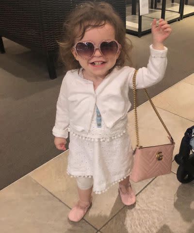 <p>Lacey Chabert Instagram</p> Lacey Chabert's daughter Julia Mimi Bella Nehdar posing with sunglasses and a purse.