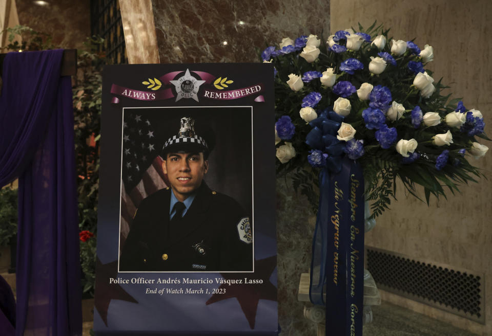 A large photo of police Officer Andres Vasquez-Lasso sits on a stand along with blue and white flowers before the start of his funeral Mass at St. Rita of Cascia Shrine Chapel on Thursday, March 9, 2023, in Chicago. Vasquez-Lasso was shot and killed as he responded to reports of a man chasing a woman with a gun in Gage Park. (Stacey Wescott/Chicago Tribune via AP, Pool)