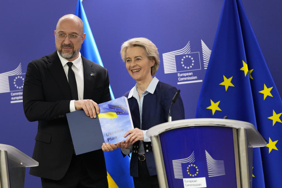 Ukraine's Prime Minister Denys Shmyhal, left, presents a book to European Commission President Ursula von der Leyen as they pose for photographers prior to a meeting at EU headquarters in Brussels, Wednesday, March 20, 2024. (AP Photo/Virginia Mayo)