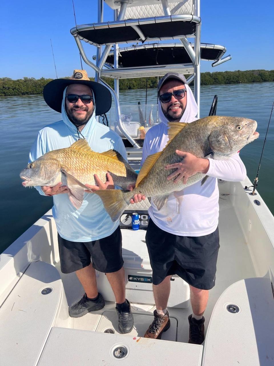 Katchesco Calavetti (right) with black drum caught fishing with Capt. Brett Norris in Tampa Bay.