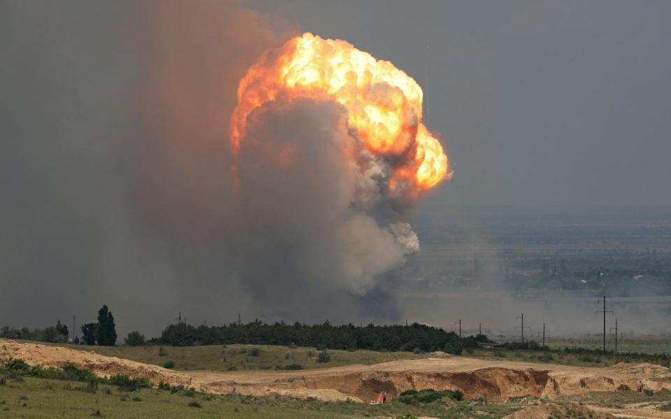 Smoke and flames rise from an explosion during a fire at a military training ground in the Kirovske district, Crimea