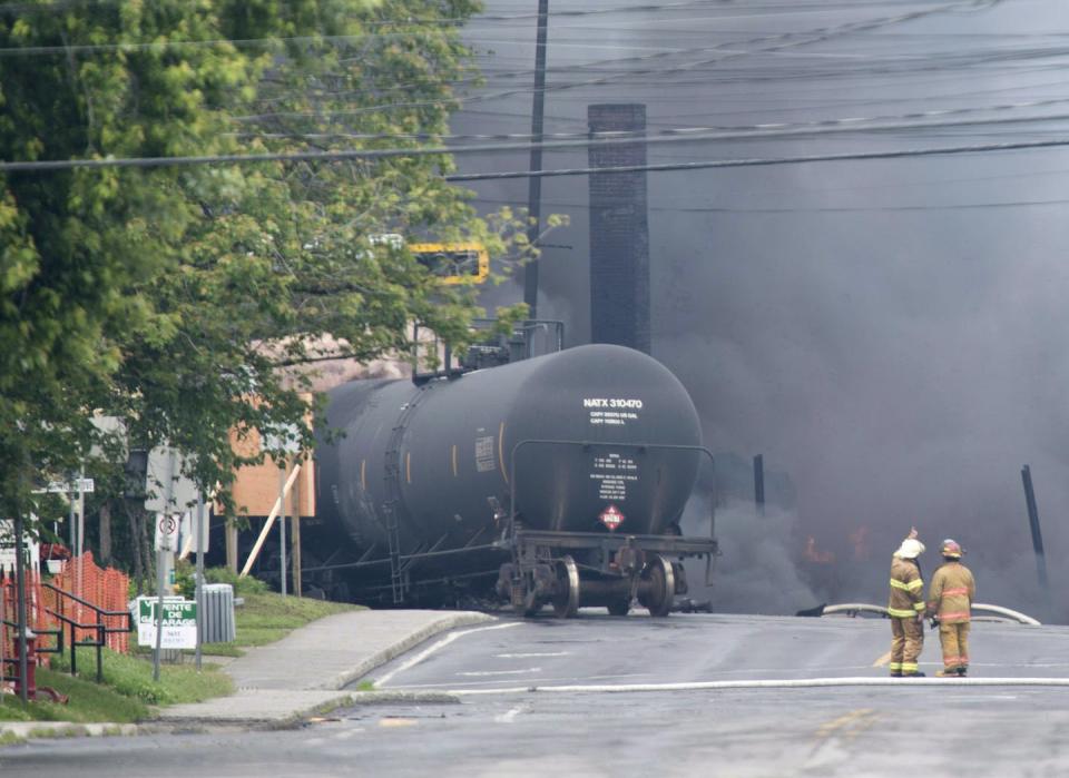 Smoke rises from railway cars that were carrying crude oil after derailing in downtown Lac-Mégantic, Que., on July 6, 2013. THE CANADIAN PRESS/Paul Chiasson