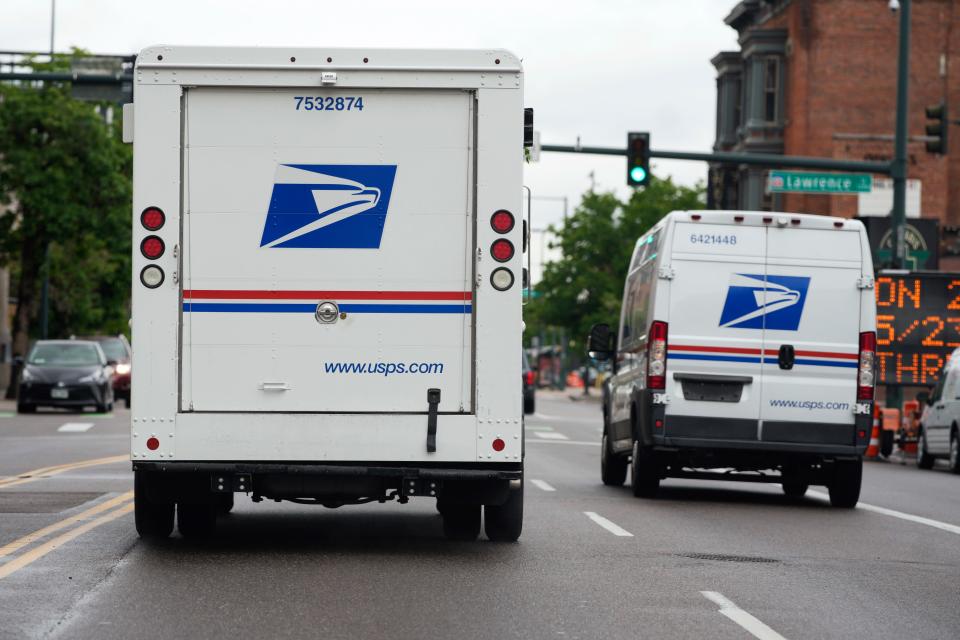 A USPS logo adorns the back doors of United States Postal Service delivery vehicles as they proceed westbound along 20th Street from Stout Street and the main post office in downtown Denver, Wednesday, June 1, 2022. USPS is creating a division to handle election mail issues as part of an effort to ensure swift and secure delivery of ballots for the 2022 midterm election, officials said Wednesday, July 27, 2022.