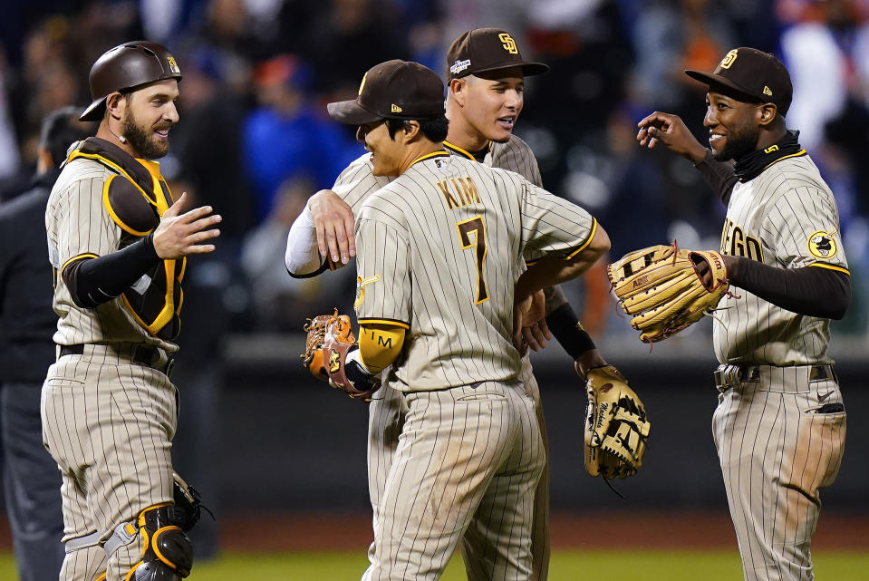 San Diego Padres third baseman Manny Machado and shortstop Ha-Seong Kim (7) celebrate with catcher Austin Nola (26) and left fielder Jurickson Profar (10) after the Padres defeated the New York Mets in Game 3 of a National League wild-card baseball playoff series, Sunday, Oct. 9, 2022, in New York. (AP Photo/Frank Franklin II)