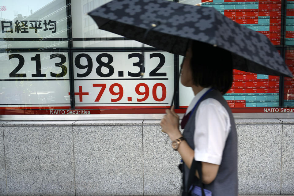 A woman walks past an electronic stock board showing Japan's Nikkei 225 index at a securities firm in Tokyo Tuesday, Sept. 10, 2019. Asian shares were mixed Tuesday after a day of listless trading on Wall Street, as investors awaited signs on global interest rates.(AP Photo/Eugene Hoshiko)