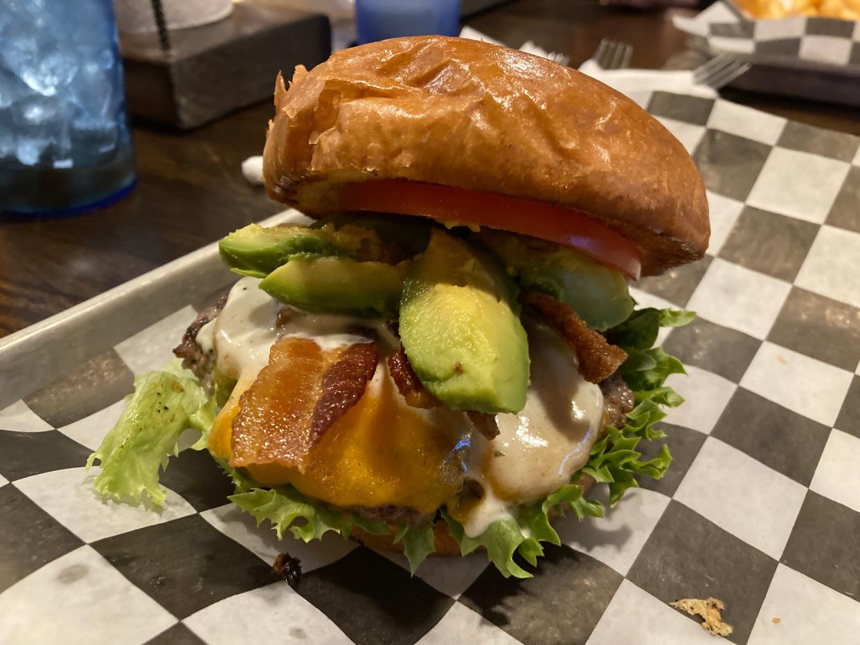 An avocado ranch burger is served with lettuce, tomato, bacon, fresh avocado and ranch at Menches Brothers in Green.