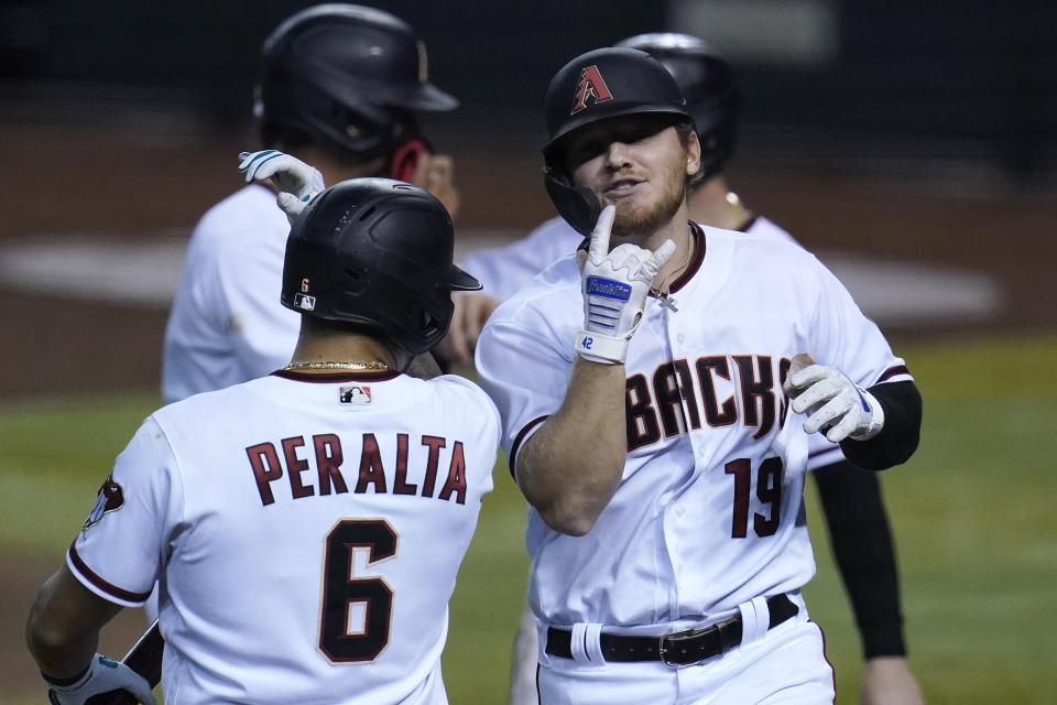 Arizona Diamondbacks' Josh VanMeter (19) celebrates his three-run home run against the Colorado Rockies with David Peralta (6) during the third inning during the second game of a baseball doubleheader Friday, Sept. 25, 2020, in Phoenix. (AP Photo/Ross D. Franklin)