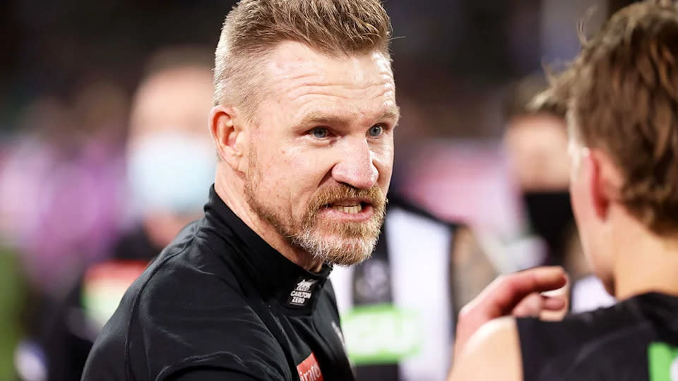 Pictured here, Nathan Buckley talks to Collingwood players during an AFL match.