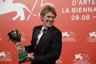 File - Actor Willem Dafoe holds the Coppa Volpi Best Actor award for 'At Eternity's Gate' at the Venice Film Festival. The 77th Venice Film Festival will kick off on Wednesday, Sept. 2, 2020, but this year's edition will be unlike any others. Coronavirus restrictions will mean fewer Hollywood stars, no crowds interacting with actors and other virus safeguards will be deployed. (AP Photo/Kirsty Wigglesworth, File)