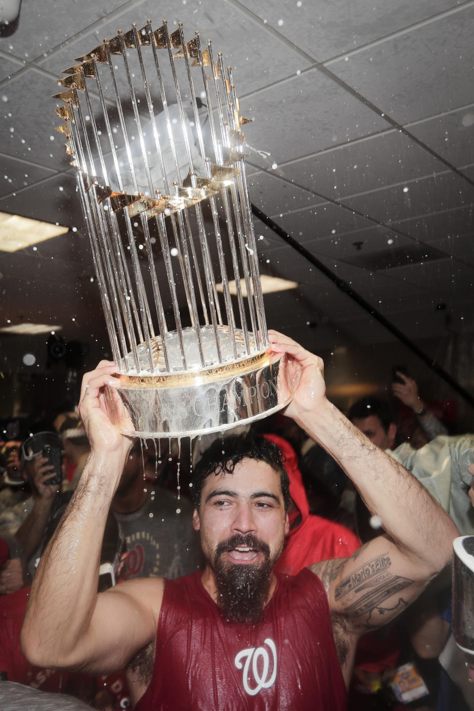 Washington Nationals third baseman Anthony Rendon celebrates with the trophy in the locker room after Game 7 of the baseball World Series against the Houston Astros Wednesday, Oct. 30, 2019, in Houston. The Nationals won 6-2 to win the series. (AP Photo/David J. Phillip)