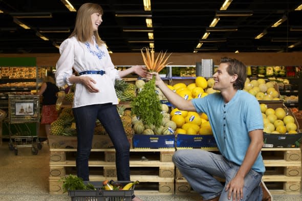 Man propose with carrots in supermarket